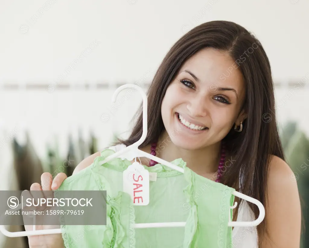 Mixed race woman shopping in clothing store