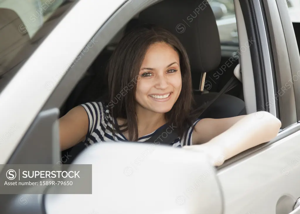 Mixed race woman driving car