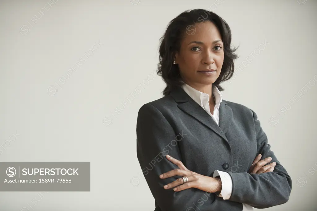 Mixed race businesswoman with arms crossed