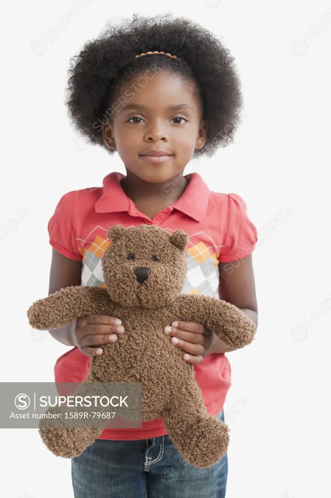 Mixed race girl holding teddy bear