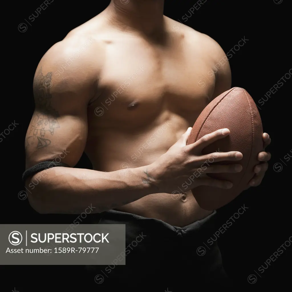 Midsection of bare chested football player