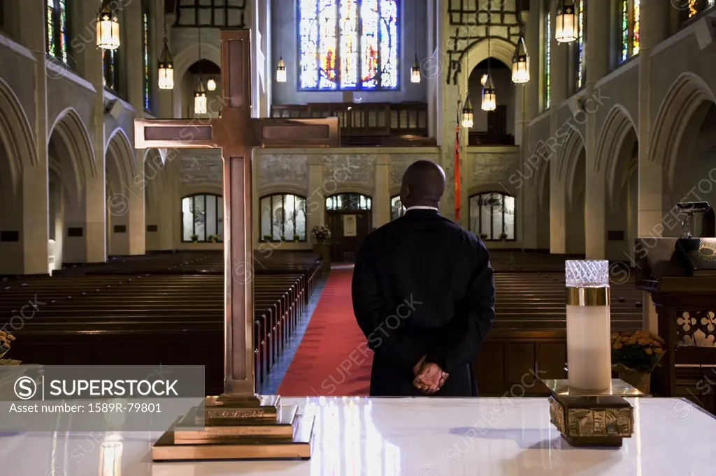 Mixed race pastor standing in front of church altar