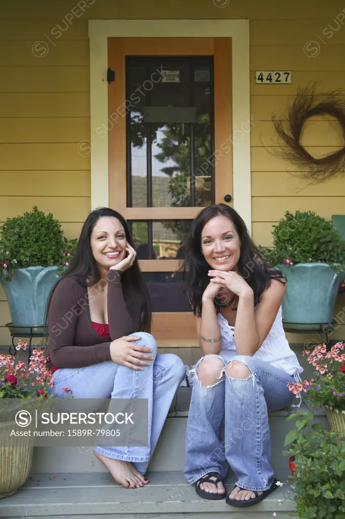 Sisters sitting together on porch