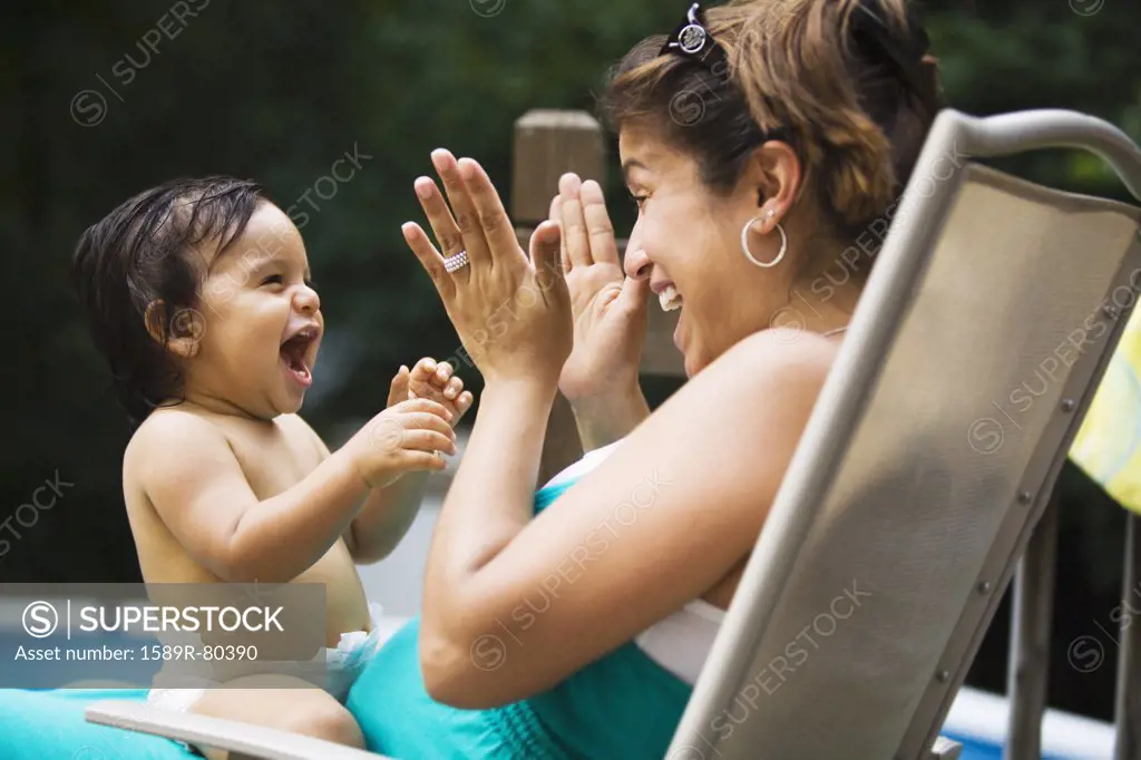 Hispanic mother playing with baby boy
