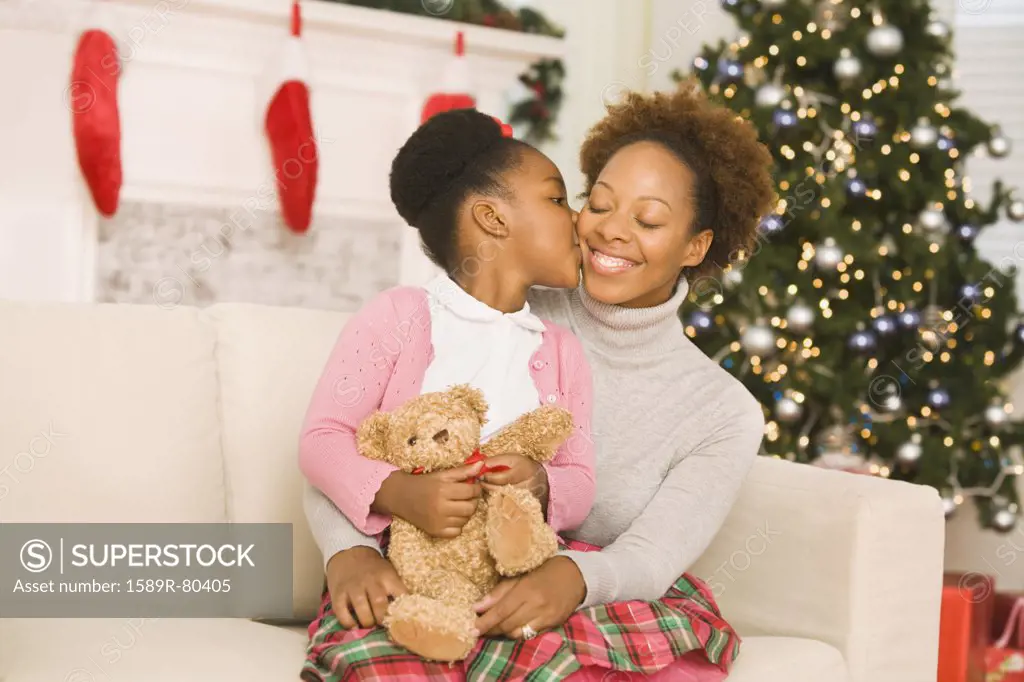 African girl kissing mother at Christmas