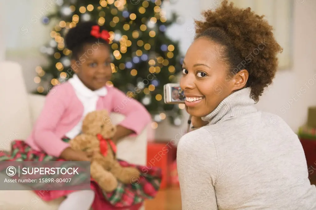 African mother taking picture of daughter at Christmas