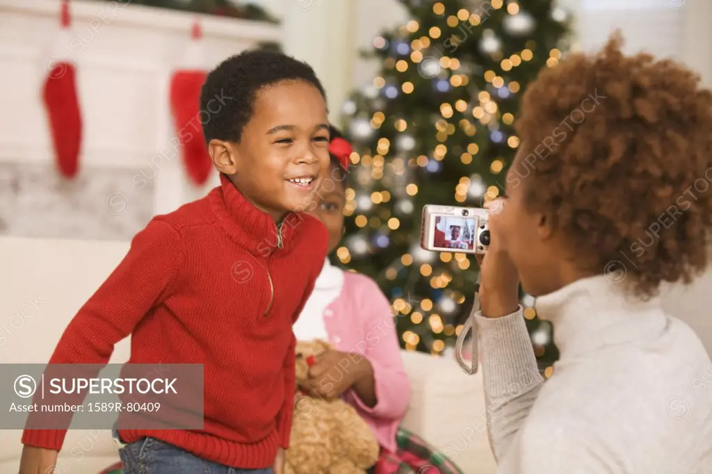 African mother taking picture of son at Christmas
