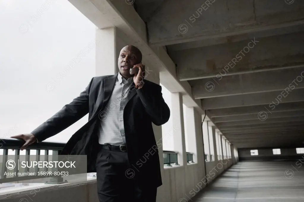 African businessman talking on cell phone in parking garage
