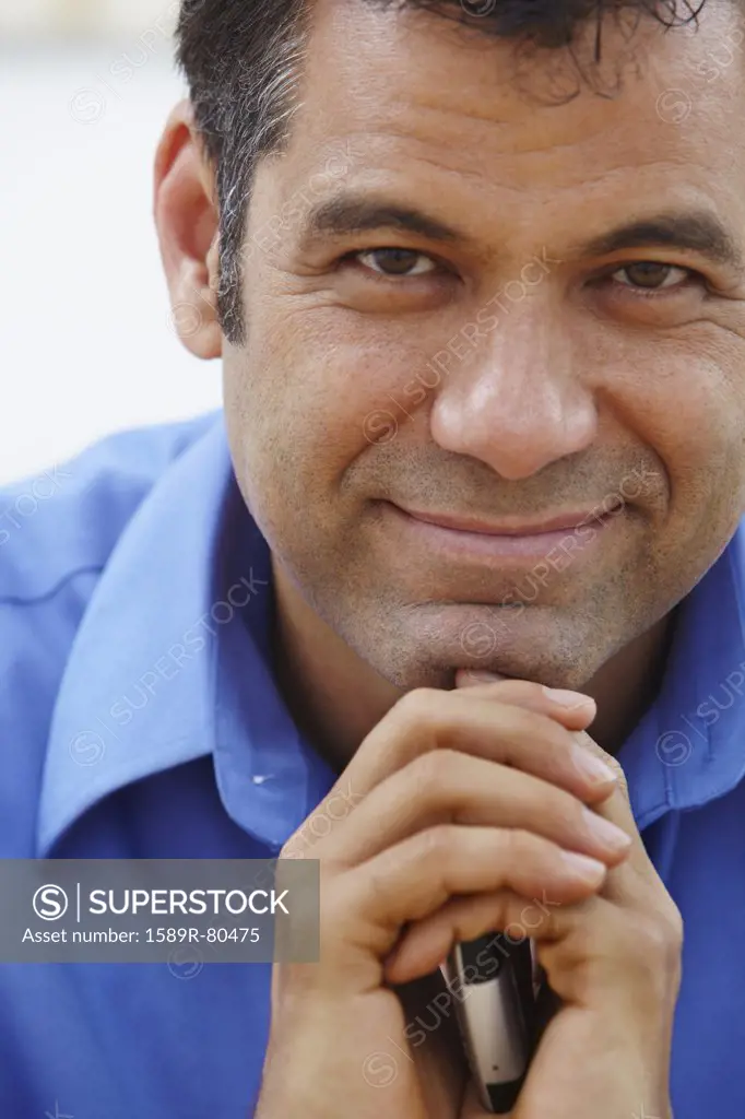 Close up of Hispanic businessman holding cell phone