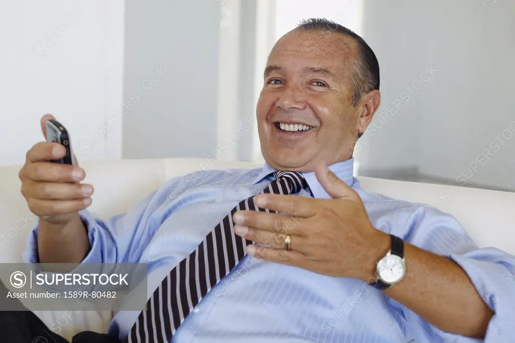 Hispanic businessman holding cell phone