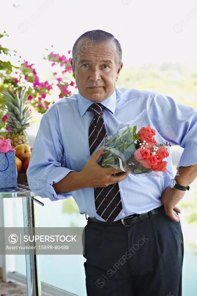Hispanic businessman holding bouquet of flowers