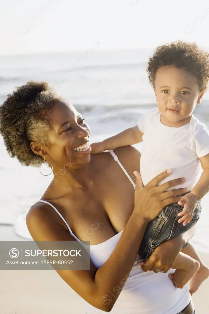 African mother holding son on beach