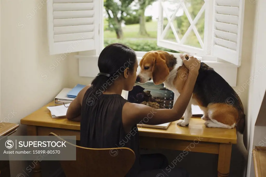 African woman at desk with dog