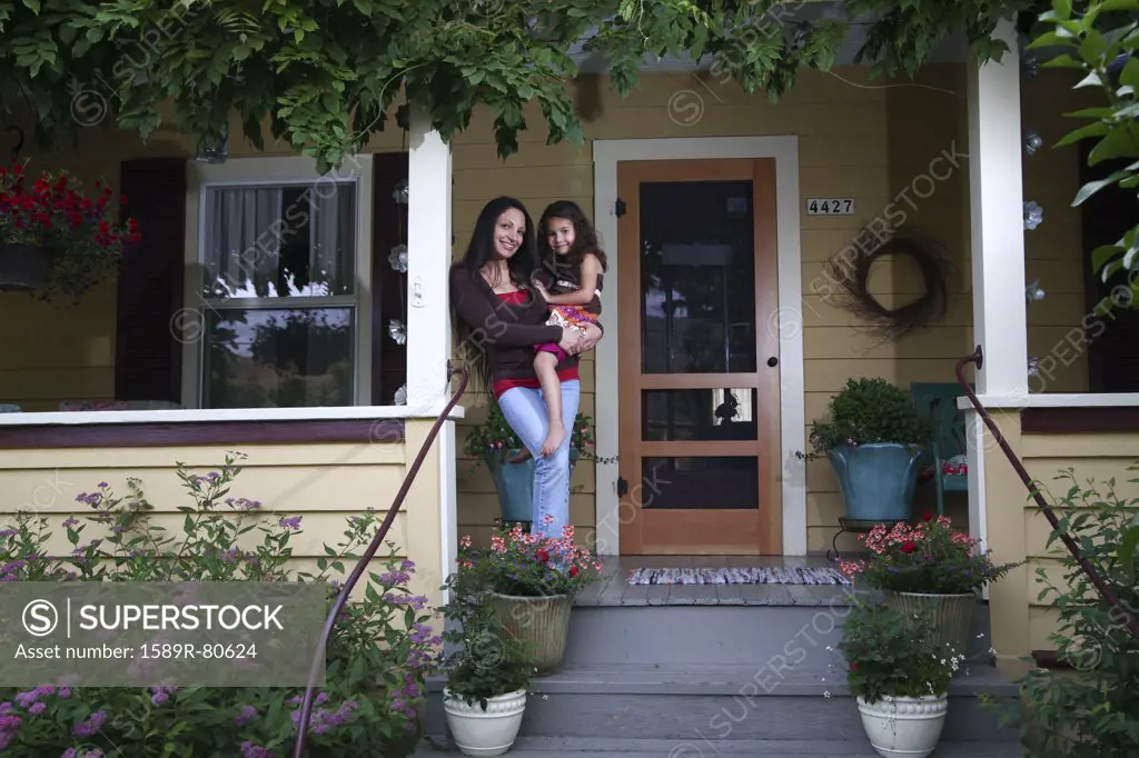 Mother standing on porch with daughter