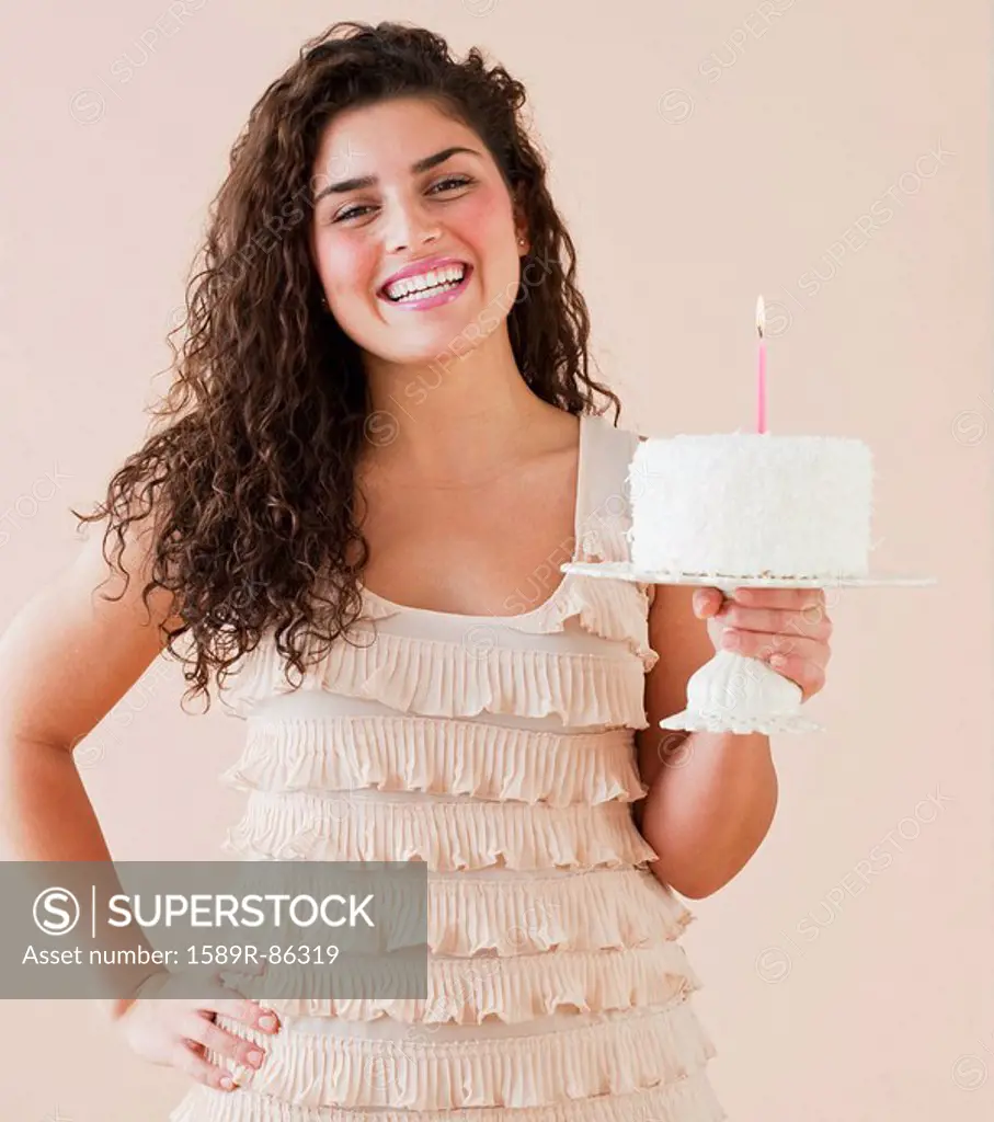 Mixed race woman holding birthday cake