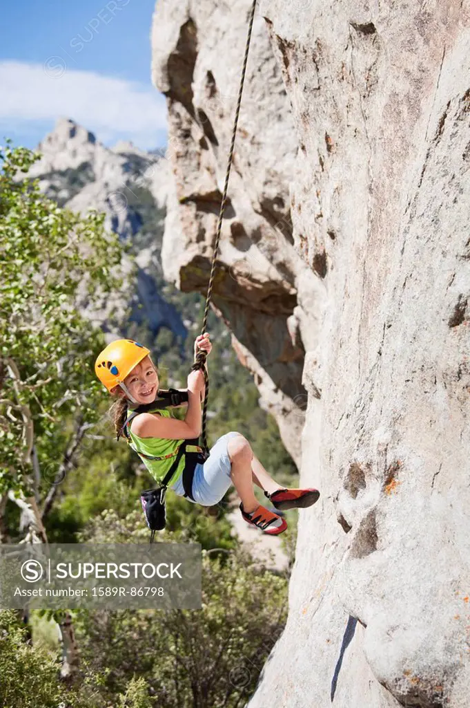 Mixed race girl rock climbing