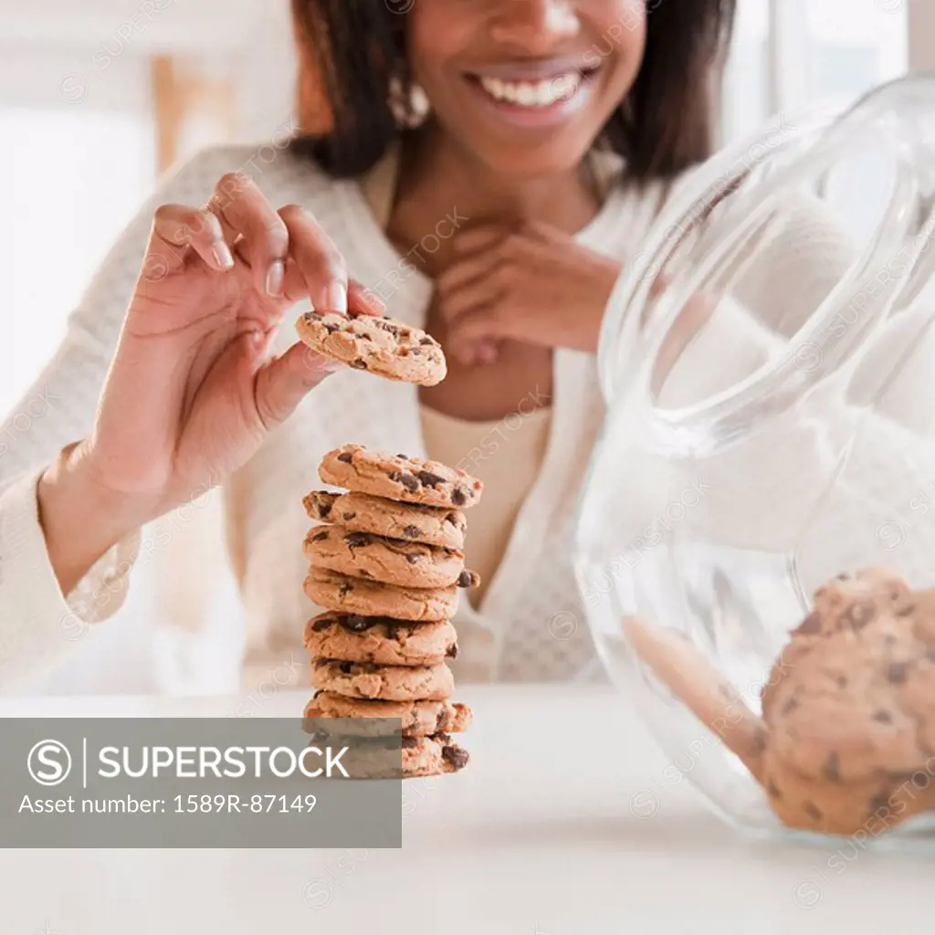 Mixed race woman taking cookie