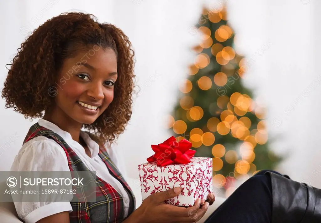 Mixed race woman holding Christmas gift