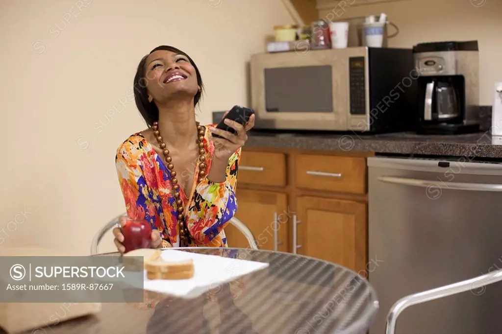 Mixed race businesswoman eating lunch in break room
