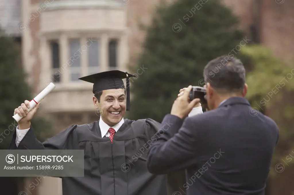 Mature male graduate in cap and gown with diploma