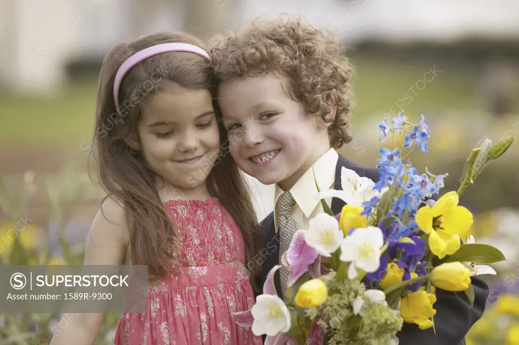 Boy and girl outdoors holding bouquet