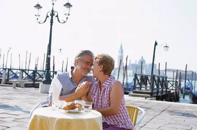 Senior couple eating at sidewalk cafe, Venice, Veneto, Italy