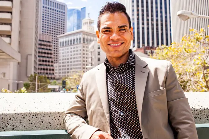 Hispanic businessman smiling in city,