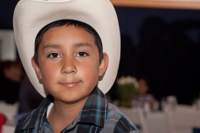 Hispanic boy wearing cowboy hat