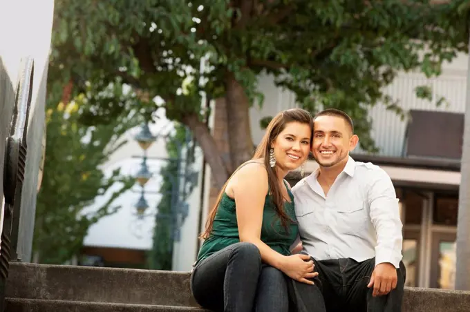 Hispanic couple sitting together on steps