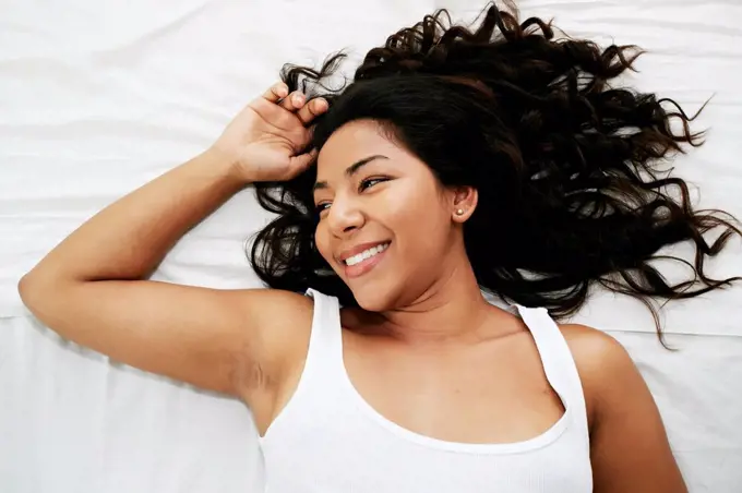 Hispanic woman laying on bed
