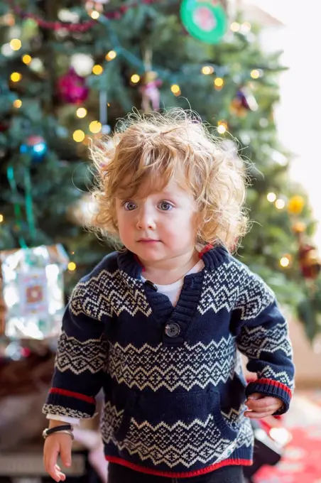 Caucasian baby boy decorating Christmas tree