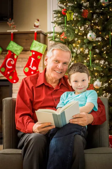 Caucasian grandfather reading to grandson at Christmas