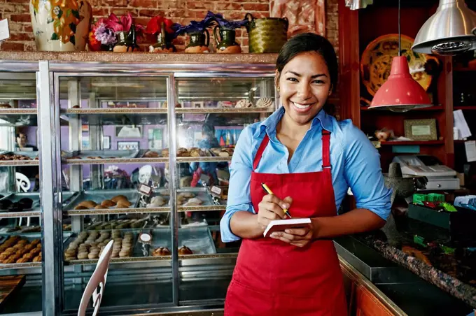 Hispanic waitress taking orders in bakery