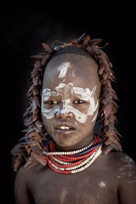 Black teenage girl wearing traditional face paint