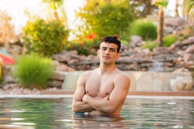 Hispanic man standing in swimming pool
