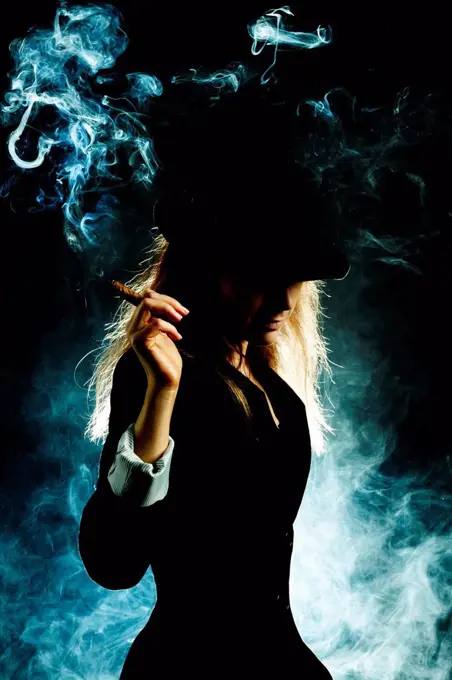 Silhouette of Caucasian woman smoking cigar