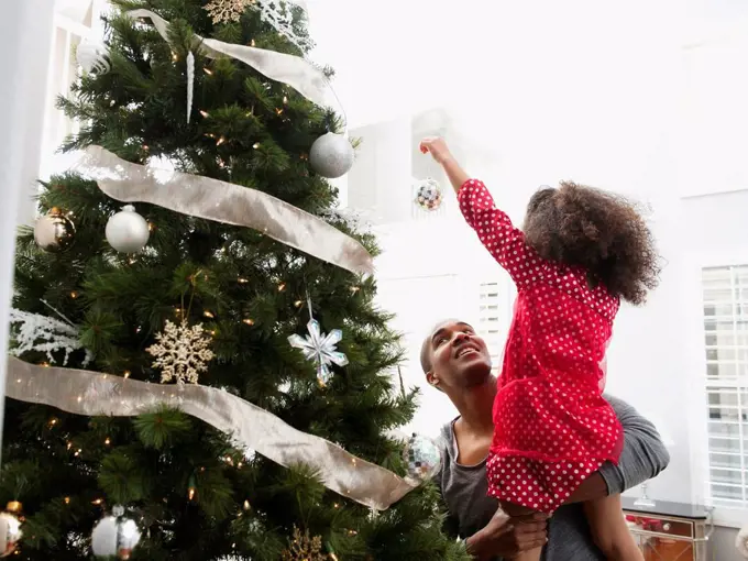 Father and daughter decorating Christmas tree