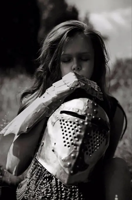 Caucasian girl carrying armor outdoors