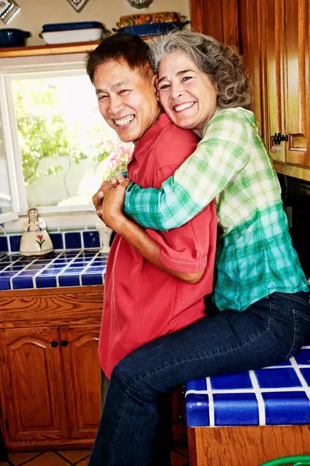 Smiling couple hugging in kitchen