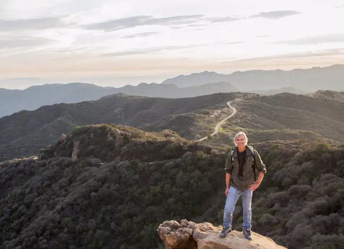 Older Caucasian man standing on rocky hilltop