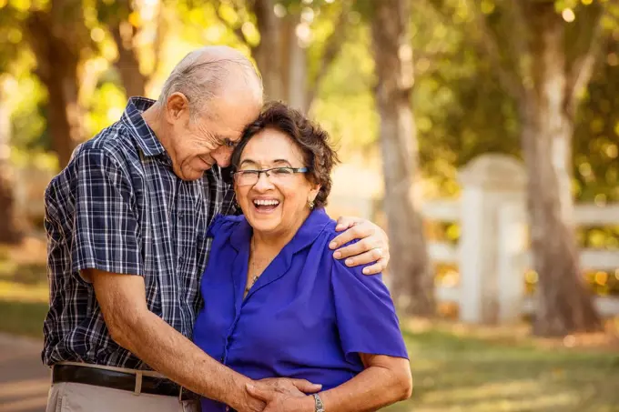 Older couple hugging in backyard