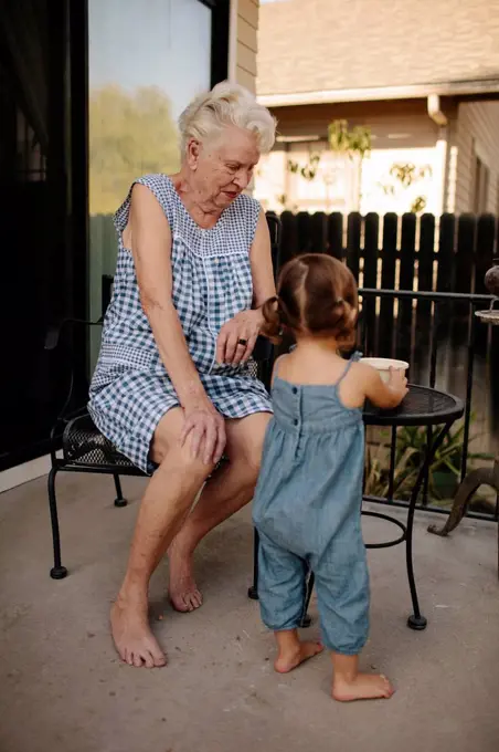 Grandmother and granddaughter playing on patio
