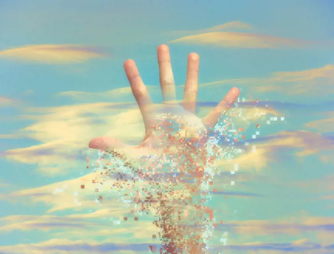 Pixelated hand dissolving in sky