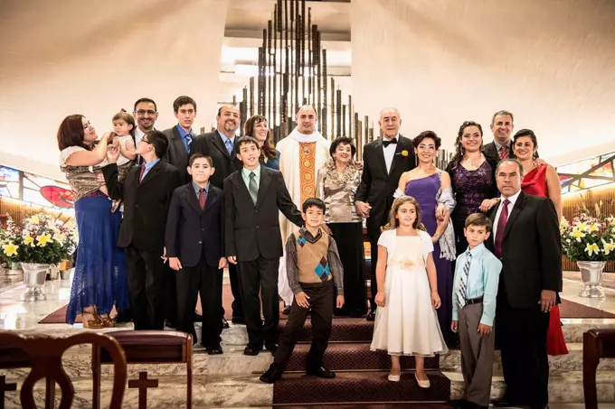 Family posing at wedding in church