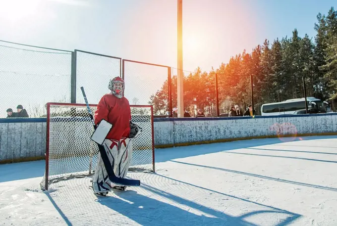 Caucasian boy playing goalie in ice hockey outdoors
