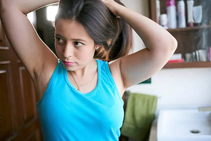 Hispanic woman lifting hair