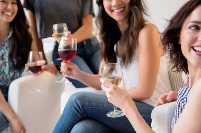 Smiling women drinking wine at party