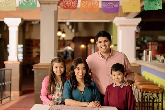 Portrait of smiling Hispanic family in restaurant