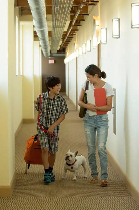 Asian mother and son in corridor with dog