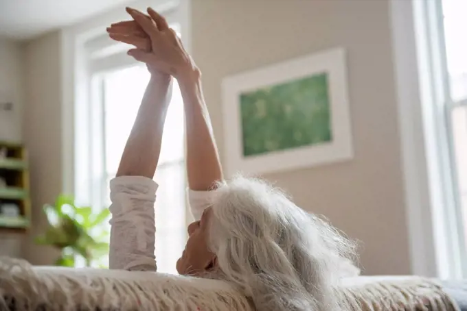 Older woman stretching with arms raised